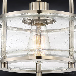 Close-up of the Urban Ambiance UQL3280 Utilitarian Ceiling Light from the Clearwater Collection, featuring a modern brushed nickel finish and a clear, bubble-patterned glass shade, reminiscent of a glass globe fixture—shown here illuminated with a filament bulb inside.