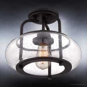 The Urban Ambiance UQL3281 Utilitarian Ceiling Light, from the Clearwater Collection, features a round clear glass cover with a visible vintage-inspired filament bulb, elegantly mounted on a dark bronze frame. Dimensions: 10