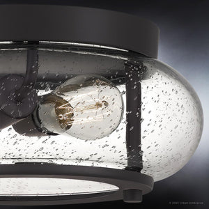 Close-up of Urban Ambiance's UQL3291 Utilitarian Ceiling Light from the Clearwater Collection, featuring a clear, seedy glass shade and dark bronze finish, revealing a single exposed bulb inside. Dimensions: 5.75