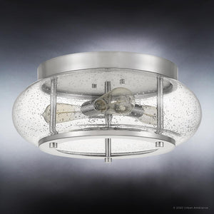 The UQL3300 Utilitarian Ceiling Light from Urban Ambiance’s Clearwater Collection features a round, brushed nickel base and a clear seeded glass dome with bubble details, showcasing two visible bulbs inside. This 7-inch high by 16-inch wide flush mount blends elegance and contemporary style for any space.