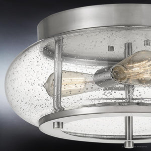 Close-up of the UQL3300 Utilitarian Ceiling Light from Urban Ambiance’s Clearwater Collection, showcasing two exposed bulbs within a clear seeded glass shade enhanced with small bubble-like details, all elegantly framed in a sleek brushed nickel flush mount measuring 7″ high by 16″ wide.