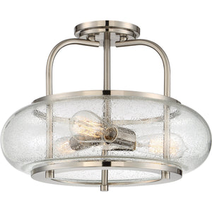 The Urban Ambiance UQL3310 Utilitarian Ceiling Light from the Clearwater Collection features a brushed nickel finish, a clear seeded glass shade, and accommodates two exposed bulbs. Sized at 12″ high by 16″ wide, this semi-flush mount fixture adds contemporary style to your space.