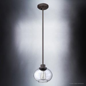 The UQL3321 Utilitarian Pendant Light from the Clearwater Collection by Urban Ambiance features a clear glass globe, dark bronze finish, and long metallic rod. At 7.5