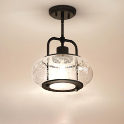 The UQL3331 Utilitarian Pendant Light from Urban Ambiance's Clearwater Collection features a nautical aesthetic with a dark bronze metal frame and an oversized clear seedy glass shade, accommodating a single bulb. Dimensions: 9.5"H x 10"W.
