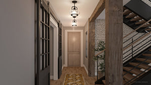 The hallway showcases wooden flooring, a patterned rug, and three Urban Ambiance UQL3331 Utilitarian Pendant Lights with clear seedy glass shades. A brick accent wall enhances the nautical vibe, while stairs rise elegantly on the right.