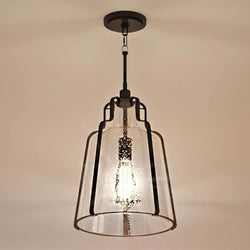 An Urban Ambiance pendant lighting fixture with a beautiful glass shade hanging from the ceiling.