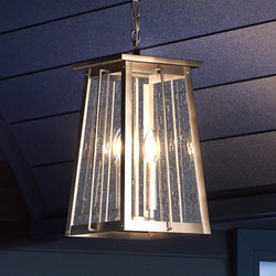A unique lighting fixture, the Urban Ambiance UEX1028 Craftsman Outdoor Pendant, with an antique brass finish, is hanging from the ceiling of a house.