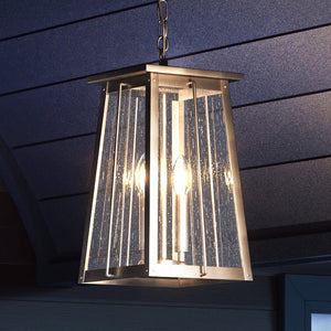A unique lighting fixture, the Urban Ambiance UEX1028 Craftsman Outdoor Pendant, with an antique brass finish, is hanging from the ceiling of a house.