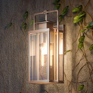 An Urban Ambiance UEX1036 Lux Industrial Outdoor Wall Sconce, Antique Brass Finish, Knoxville Collection with ivy growing on it.