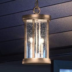 A beautiful Urban Ambiance UEX1048 Nautical Outdoor Pendant lighting fixture, Antique Brass Finish, Rockland Collection hanging from the ceiling of a house.