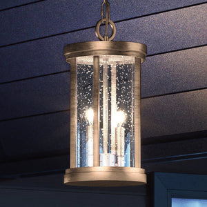 A beautiful Urban Ambiance UEX1048 Nautical Outdoor Pendant lighting fixture, Antique Brass Finish, Rockland Collection hanging from the ceiling of a house.