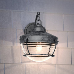 A beautiful Urban Ambiance UEX1057 Nautical Outdoor Wall Sconce 14''H x 11''W, Aged Zinc Finish, Telluride Collection with a glass shade.