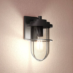 A unique lighting fixture, the UEX1065 Nautical Outdoor Wall Sconce from the Malibu Collection features a black charcoal finish and glass shade by Urban Ambiance.