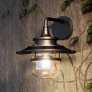 A unique farmhouse outdoor wall sconce with an oil rubbed bronze finish from the Belvidere Collection, adding a touch of luxury to any urban ambiance.