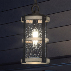 A beautiful UEX1103 Farmhouse Outdoor Pendant 15''H x 8''W lighting fixture, hanging from the side of a house.