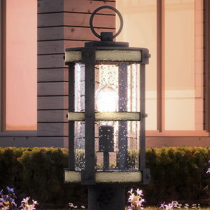 A gorgeous Farmhouse Outdoor Post Light in Olde Iron Finish from the Jackson Collection illuminates the front of a house.