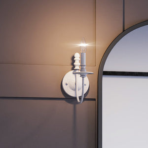 A unique UEX2261 Cottagecore wall sconce, a lighting fixture with a weathered white finish, is placed next to a mirror.