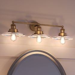 Three Urban Ambiance luxury bath lighting fixtures above a mirror in a bathroom.