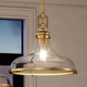 A unique UEX2510 New Traditional Pendant 13''H x 15''W, Satin Brass Finish, Vail Collection with a glass shade hanging over a window.