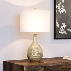 A beautiful Transitional Table Lamp 12''W x 12''D x 22''H, Gold Finish, Thomas Collection on top of a dresser.