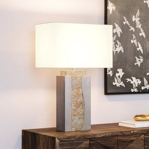 A gorgeous UEX7230 Modern-Rustic lighting fixture lamp with a white shade on a wooden table from the Urban Ambiance brand.
