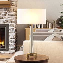 A living room with a unique Urban Ambiance UEX7270 Contemporary Table Lamp 17''W x 17''D x 30''H, Clear and Aged Brass Finish lighting fixture and