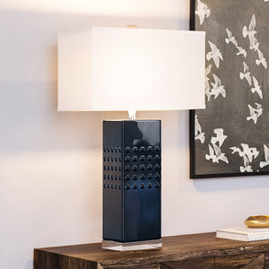 A unique lighting fixture, the Urban Ambiance UEX7600 Transitional Table Lamp, adds a gorgeous touch to any space with its Dark Blue Finish from the Mystic Collection, placed on a wooden table and