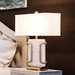A bed with a unique lighting fixture, the UEX7670 Contemporary Table Lamp 18''W x 10''D x 29''H, Pale Pink and Bronze Finish, from the Ft