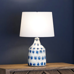 A gorgeous Coastal Table Lamp with a beautiful Blue and White Finish from the unique Bar Harbor Collection, adding to the urban ambiance on a wooden table.
