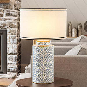 A luxury lighting fixture, the UEX7820 Traditional Table Lamp from the Rocklin Collection by Urban Ambiance, adds elegance to a living room with its blue and white finish.