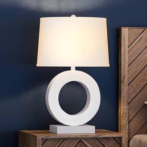 A gorgeous lamp on a nightstand next to a blue wall.