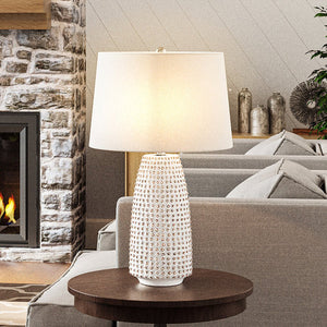 A gorgeous living room with a unique fireplace and a beautiful Urban Ambiance UEX7990 Transitional Table Lamp 16''W x 16''D x 29''H, White and