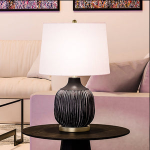 An Urban Ambiance UEX8060 Vintage Table Lamp, a unique and beautiful lighting fixture, on a table in a living room.