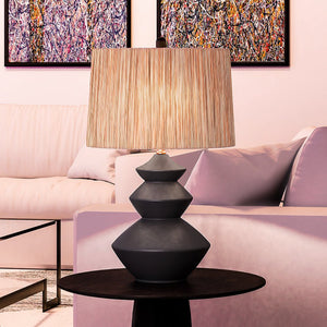 A luxury lighting fixture, the UEX8070 Modern Table Lamp with a gorgeous black glazed finish from the Lehi Collection by Urban Ambiance, is sitting on a table in a living room.