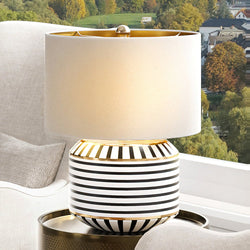 A unique UEX8080 Glam Table Lamp by Urban Ambiance on a table in front of a window.