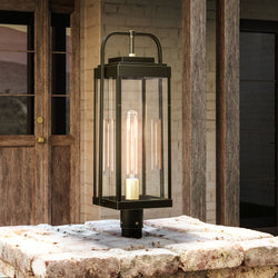 A gorgeous Outdoor Post Light, part of the beautiful Orlando Collection, featuring an Olde Bronze Finish, illuminating a stone patio.