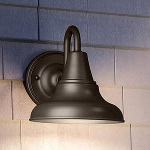A gorgeous UHP1360 Industrial Outdoor Wall Sconce in Olde Bronze Finish from the Pittsburgh Collection by Urban Ambiance accentuating a brick wall.