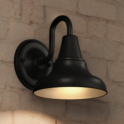 An UHP1362 Industrial Outdoor Wall Sconce 8.25''H x 8''W, Midnight Black Finish from the Pittsburgh Collection by Urban Ambiance illuminating a brick wall.