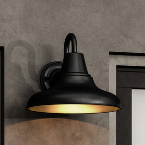 An UHP1363 Industrial Outdoor Wall Sconce, Midnight Black Finish, Pittsburgh Collection by Urban Ambiance providing beautiful lighting on a concrete wall.