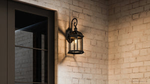 A beautiful Urban Ambiance UHP1371 Transitional Outdoor Wall Sconce with a unique Olde Bronze Finish, Greensboro Collection on a brick wall.