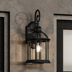 A unique Urban Ambiance UHP1377 Transitional Outdoor Wall Sconce adds a touch of luxury to a concrete wall in the Greensboro Collection with its Midnight Black finish.
