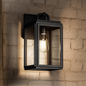 The Urban Ambiance UHP1381 Macon Collection Farmhouse Outdoor Wall Sconce, 13.625''H x 7.125''W, features marine-grade construction and an Olde Bronze finish with clear glass panels for lasting style and durability on any outdoor wall.