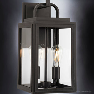 The UHP1382 Farmhouse Outdoor Wall Sconce by Urban Ambiance features a 17.125''H x 9''W marine-grade build, Olde Bronze finish, and clear glass panels for classic style and durability in the Macon Collection.