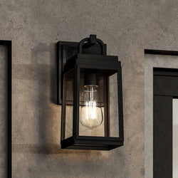 A UHP1385 Farmhouse Outdoor Wall Sconce with a unique Midnight Black Finish from the Macon Collection by Urban Ambiance on a concrete wall.
