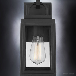 Close-up of the Urban Ambiance UHP1385 Farmhouse Outdoor Wall Sconce from the Macon Collection, featuring marine-grade construction and a midnight black finish, measuring 11.875''H x 5.5''W, with a glowing exposed filament bulb inside.