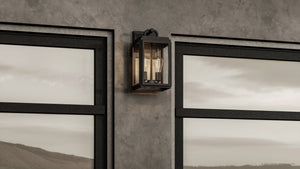 The Urban Ambiance UHP1387 Farmhouse Outdoor Wall Sconce, 17''H x 9''W, features marine-grade midnight black metal and coastal style from the Macon Collection, mounted between two large windows on a concrete wall.