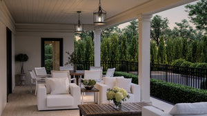 A porch with a unique UHP1420 Farmhouse Outdoor Pendant and Gilbert Collection furniture, creating a luxurious and gorgeous ambiance.