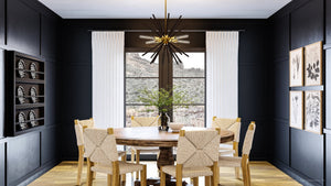 A unique dining room with black walls and wooden floors.