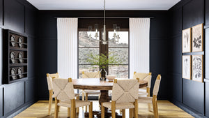 A gorgeous dining room with unique black walls and wooden floors, adorned with the UHP3981 New Traditional Chandelier 24.375''H x 23''W from the Griffith Collection by Urban