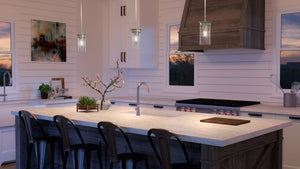 A kitchen with a large island and bar stools, featuring the beautiful UHP3983 New Traditional Pendant 8.875''H x 5''W from the Griffith Collection by Urban Ambiance,
